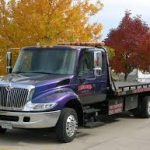 Purple flatbed tow truck service